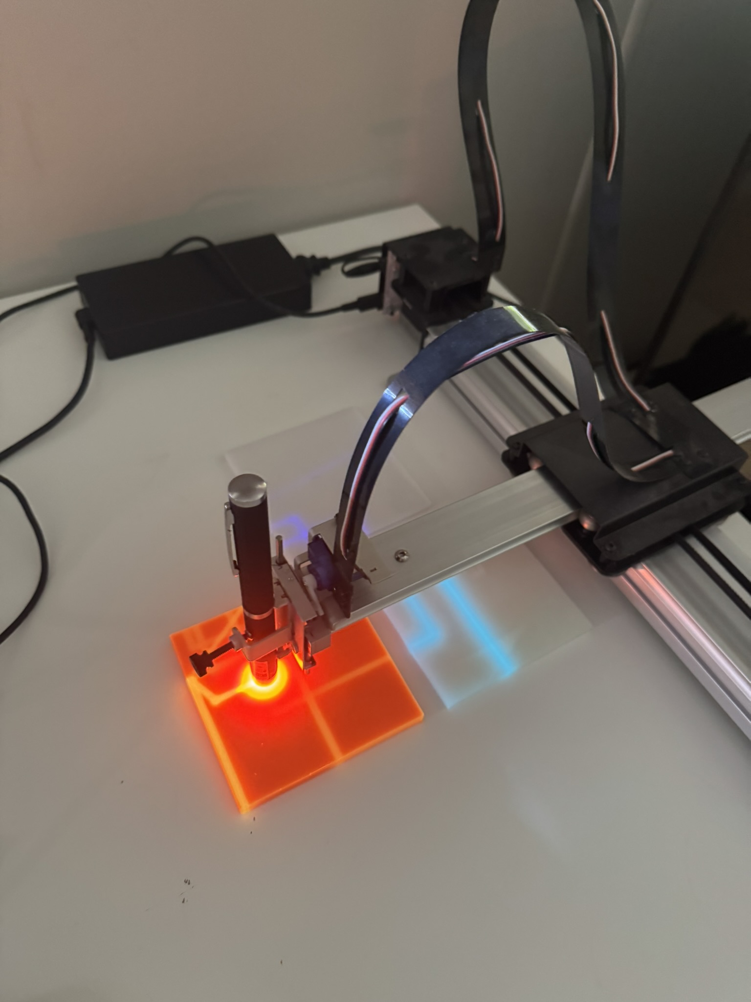 UV-Drawn Glow Castings - UV laser tracing paths across a tile on the AxiDraw